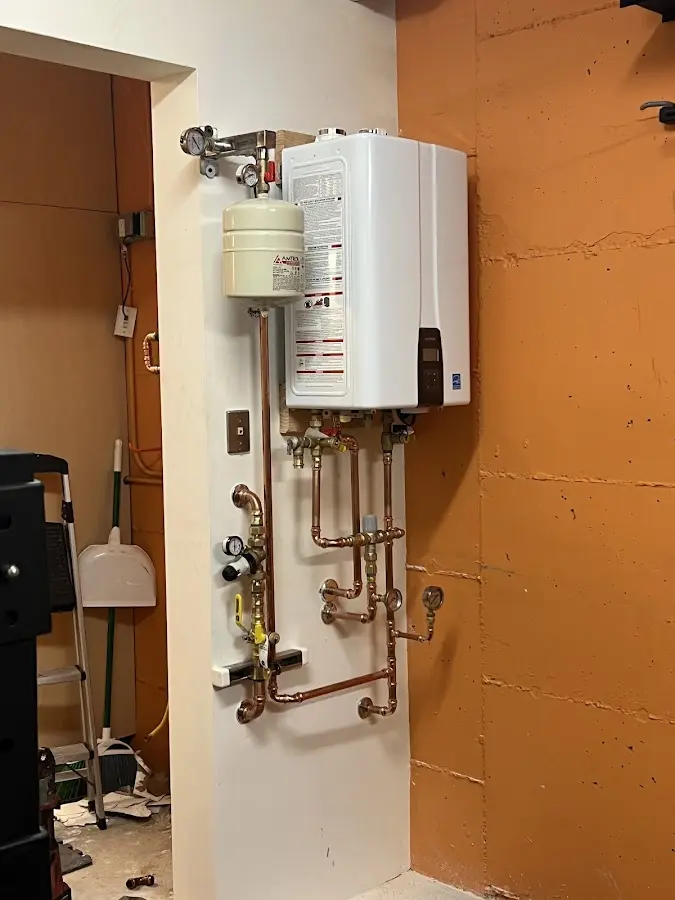 Plumbing technician inspecting water heater connections in Stepping Stone